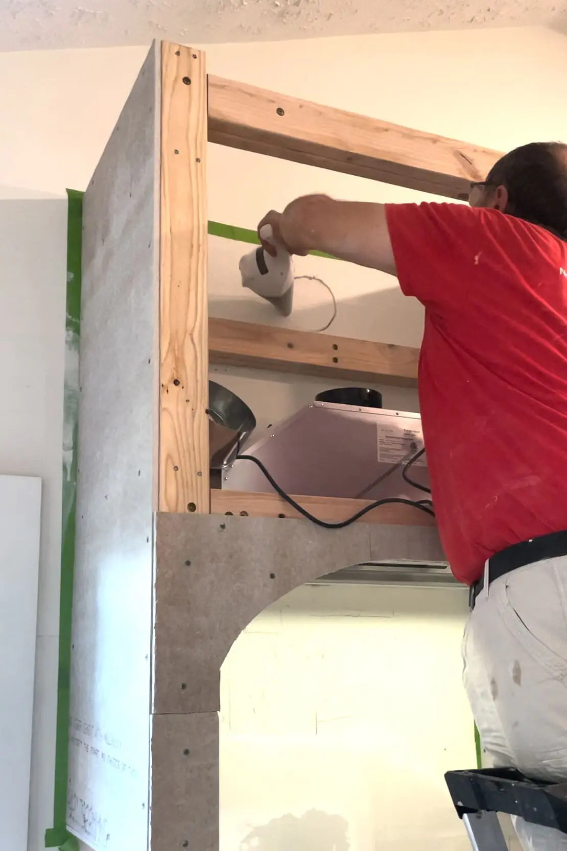 Cutting hole for vent on range hood.